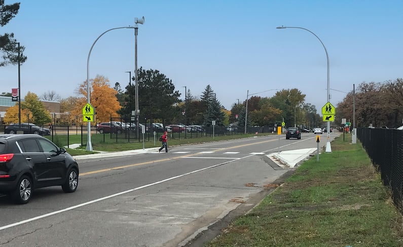 Photo of a person crossing a street at pedestrian crossing