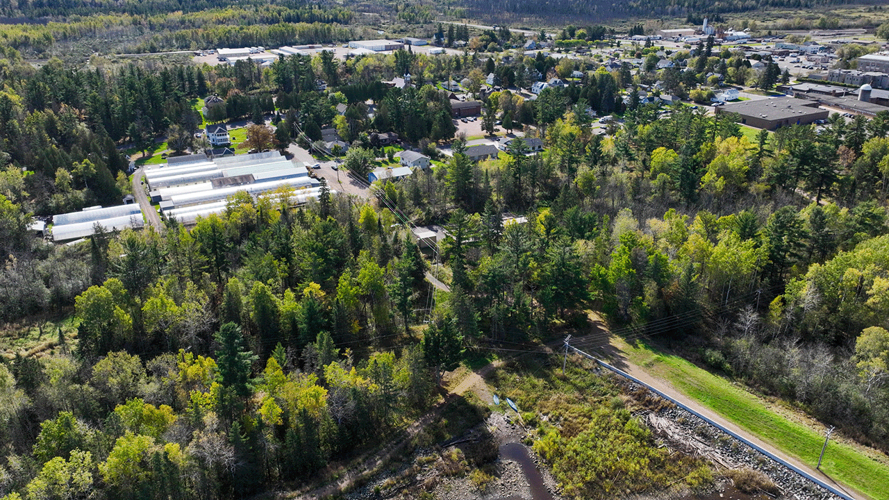 Aerial view of the Carlton Pump Station surrounded by dense trees and nearby buildings.