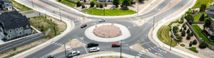 Aerial view of a roundabout with multiple cars navigating the intersection.