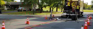 Construction crew fixing sewer pipes in roadway