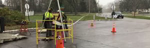 Construction workers standing by open sewer main