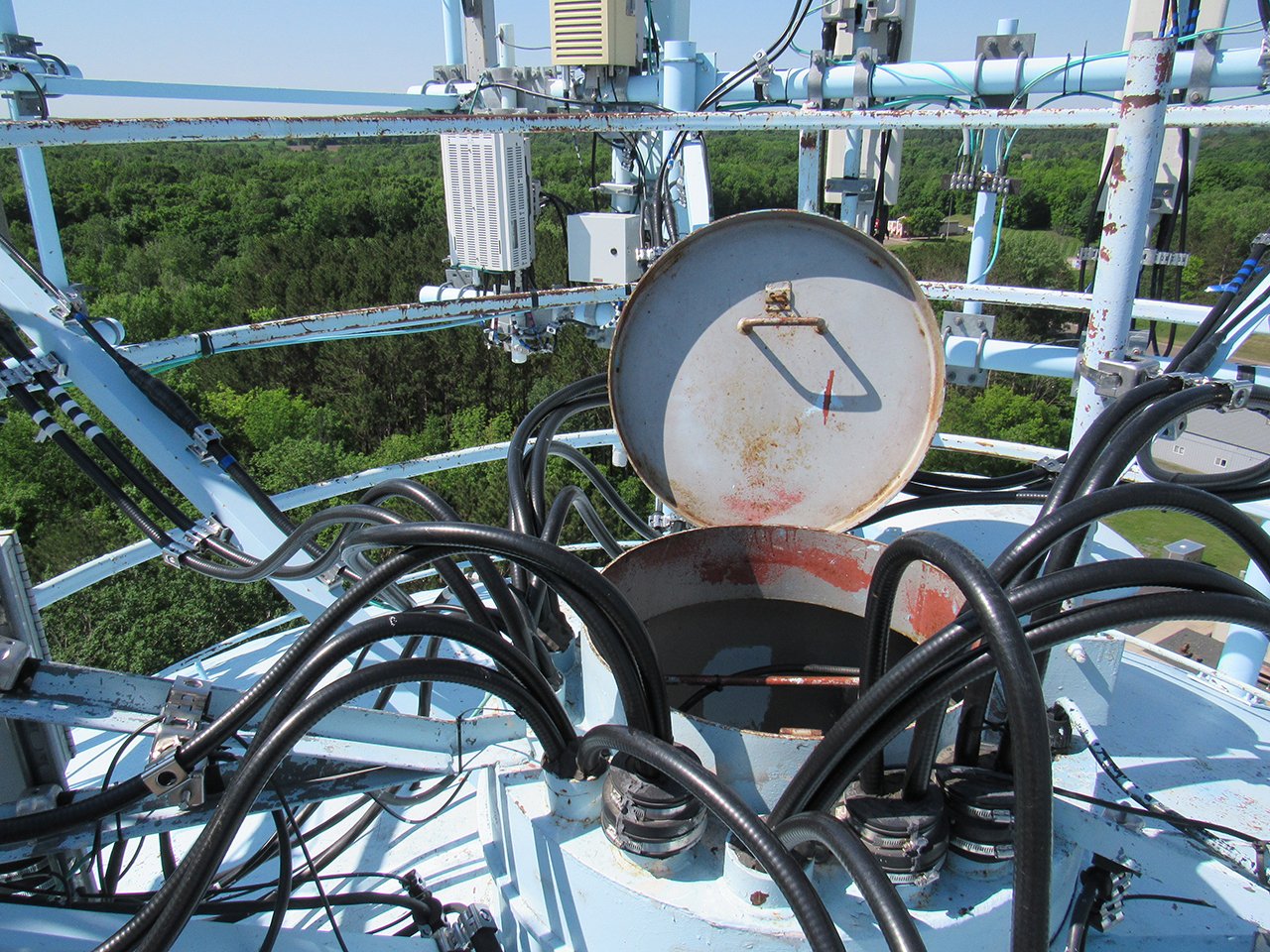 access hatch is in the middle of a mass of telecom cables